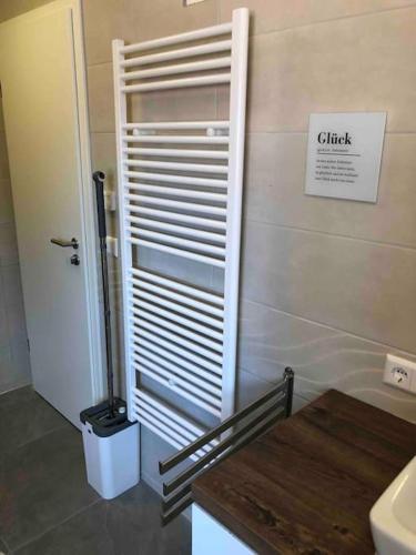 a bathroom with a sink and a toilet and a door at Stylisches Maybach Appartement mit Terrasse für 5 Personen, 5 Betten, große Kochinsel, Homeoffice mit 250Mbit WLAN in Aidlingen