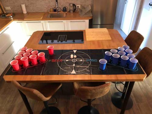 a table in a kitchen with red and blue cups on it at Stylisches Maybach Appartement mit Terrasse für 5 Personen, 5 Betten, große Kochinsel, Homeoffice mit 250Mbit WLAN in Aidlingen