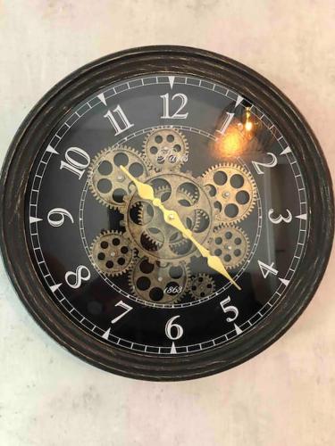 a clock with gears on it hanging on a wall at Stylisches Maybach Appartement mit Terrasse für 5 Personen, 5 Betten, große Kochinsel, Homeoffice mit 250Mbit WLAN in Aidlingen