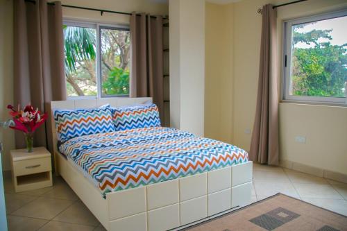 sypialnia z łóżkiem i oknem w obiekcie Acquah Place Residences w Akrze