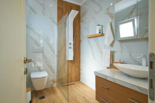 a bathroom with a glass shower and a sink at Villa del Capitano in Corfu Town