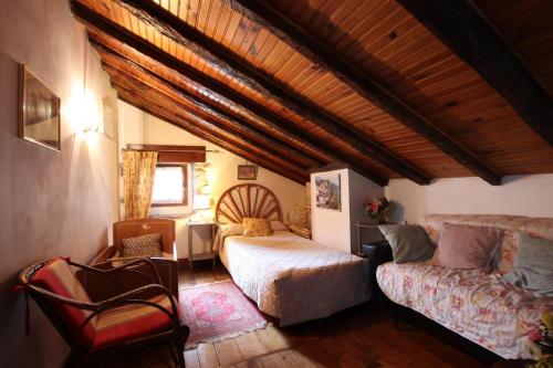 Un dormitorio con una cama y un sofá en una habitación. en Chez aguirre, en Saint-Jean-Pied-de-Port