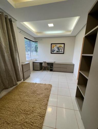 an empty room with a desk and a rug at Casa Maravilhosa em condominio in Luis Eduardo Magalhaes