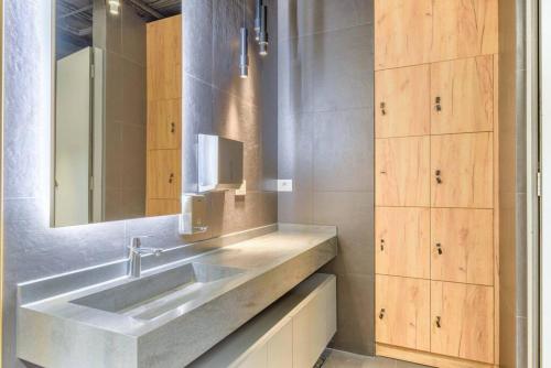 ein Bad mit einem Waschbecken und einem Spiegel in der Unterkunft Denim 3 Bedroom Apartment With Pool in Beirut