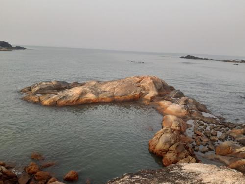 a rock in the middle of a body of water at Anika homes in Canacona