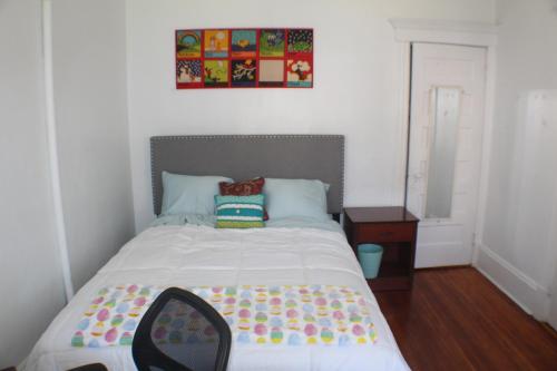 Dormitorio pequeño con cama con edredón blanco en Historic West End Gem, en Hartford