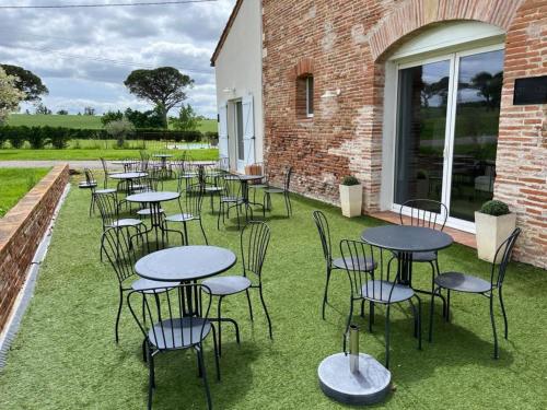 a group of tables and chairs on the grass at Ferme Binel à Ronsac in Aigrefeuille