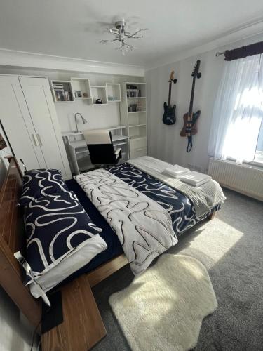 a bedroom with a bed and a guitar on the wall at Private Flat in City Centre with Parking in Southampton