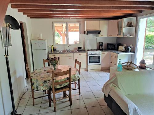 uma cozinha com uma mesa e uma sala de jantar em Gambade em Sainte-Eulalie-en-Born