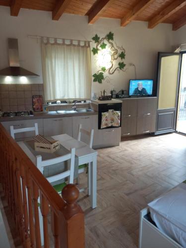a living room with a kitchen and a table at Antico Borgo - A due passi dalle Gole Alcantara in Motta Camastra
