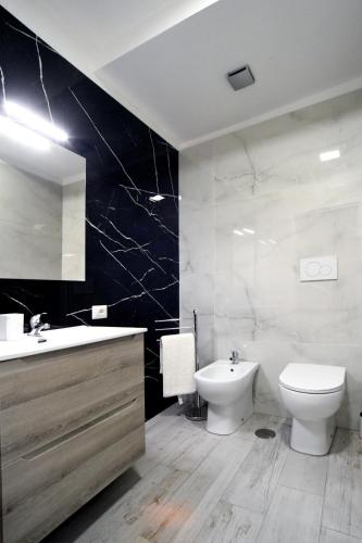La salle de bains est pourvue de toilettes blanches, d'un lavabo et de toilettes. dans l'établissement B&B L’antico cortile, à Alatri