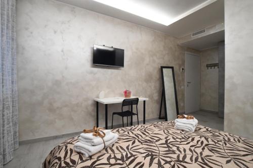 1 dormitorio con cama, mesa y TV en B&B L’antico cortile, en Alatri