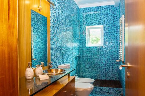baño de azulejos azules con lavabo y aseo en Casa de Linhares, en Afife