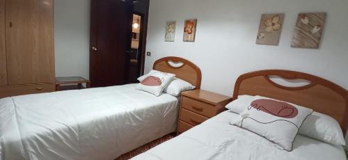 twee bedden naast elkaar in een slaapkamer bij Piso Eugenio Fadrique Vigo in Vigo