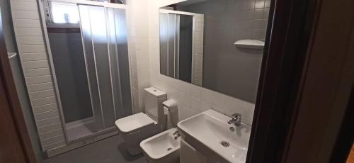 bagno con lavandino, servizi igienici e specchio di Piso Eugenio Fadrique Vigo a Vigo