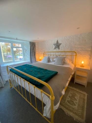 a bedroom with a bed with a green blanket on it at The Croft Apartment in Bourton on the Water