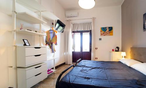 a bedroom with a bed and a dresser at Kòre rooms in Castellammare del Golfo