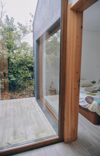 a large glass window in a room with a bed at Quinta do Abacate - Glamping Park in Angra do Heroísmo