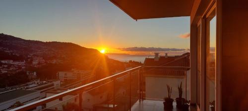 a view of the sunset from the balcony of a building at Highrise Madalenas Apartment in Funchal