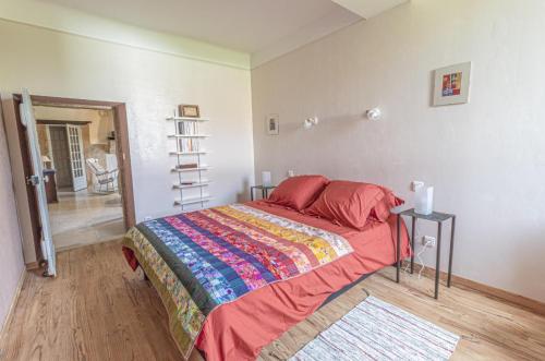 Un dormitorio con una cama con una manta de colores. en Gite de labeylie - les dunes, en Saint-André-de-Seignanx