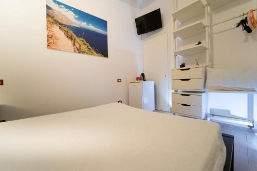 a bedroom with a white bed and a window at Kòre rooms in Castellammare del Golfo
