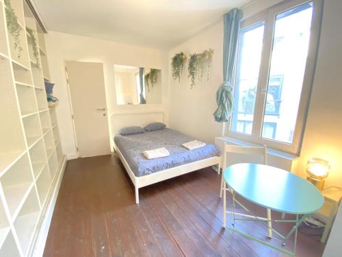 a small bedroom with a bed and a table at Charming National Street Room in the Heart of Antwerp in Antwerp