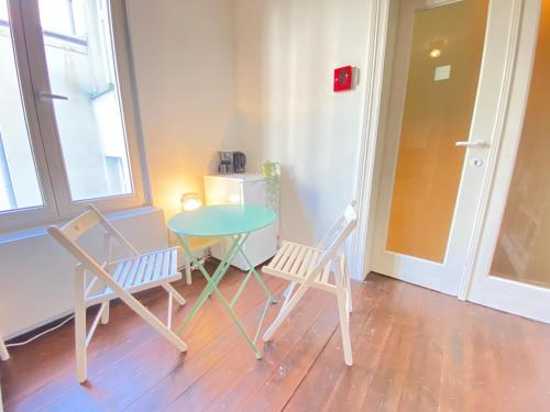a table and two chairs sitting next to a table at Charming National Street Room in the Heart of Antwerp in Antwerp
