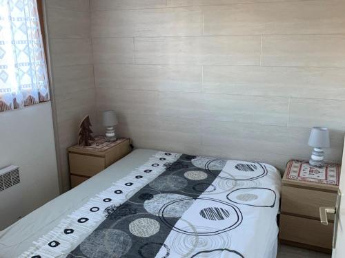 une petite chambre avec un lit et deux tables de nuit dans l'établissement Charmant T2 pour 5 pers. avec terrasse, parking privé et proximité centre-village et navettes. - FR-1-676-120, à Châtel