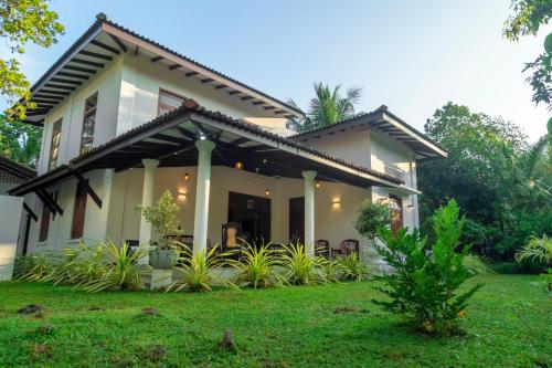 a house with a green lawn in front of it at Villa Green Space in Matara