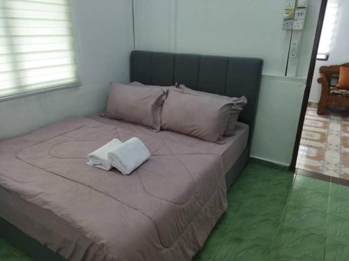 a bed with two towels on top of it at Ustazah Homestay in Kampong Ru Sepuloh