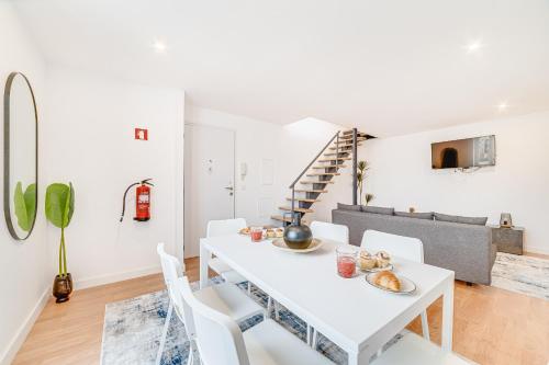 a white dining room with a white table and white chairs at Ajuda Deluxe Apartments in Lisbon