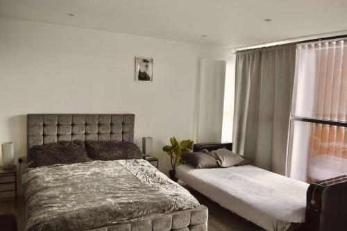 a bedroom with a large bed and a window at The Bricklane Artistic Studio in London