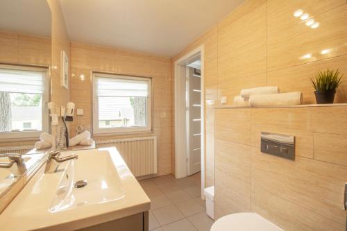 a bathroom with a sink and a mirror at Usedomer Bungalows in Korswandt