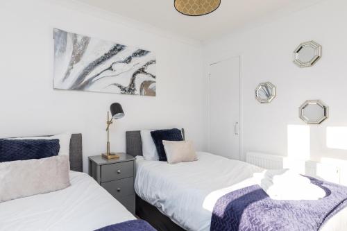 2 Betten in einem Schlafzimmer mit weißen Wänden in der Unterkunft 19A The Broadwalk Apartment- 1BR in Crawley