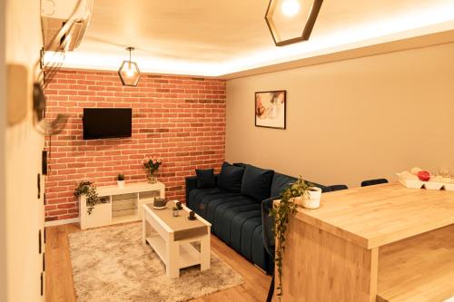 a living room with a couch and a brick wall at The Rugby Accommodation in Rugby