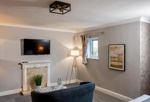 a living room with a blue chair and a fireplace at Foxfields Country Hotel in Langho