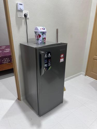 a small refrigerator with a bucket on top of it at WAJA Homestay in Kampung Raja