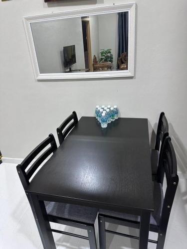 a black table with a black chair in front of a mirror at WAJA Homestay in Kampung Raja
