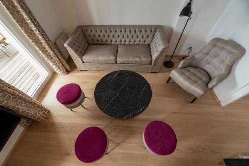 a living room with a couch and a table and chairs at Romantik Residenz (Ferienwohnungen Hotel Im Weissen Rössl) - Dependance in St. Wolfgang