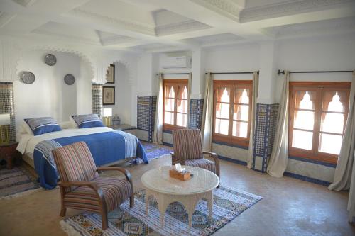 a bedroom with a bed and a table and chairs at RIAD TANJA by chef Moha in Tangier