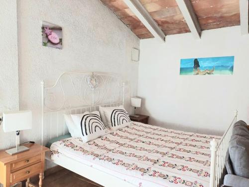 a bedroom with a white bed and a table with a lamp at La Casita in Manacor