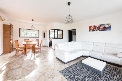 Una sala de estar con un sofá blanco y una mesa. en Villa en Provence, en Bollène