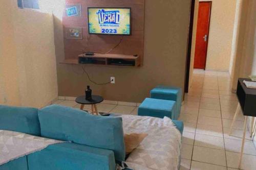 a living room with a blue couch and a tv at Apê da VAN acomoda até 7 pessoas in Garanhuns