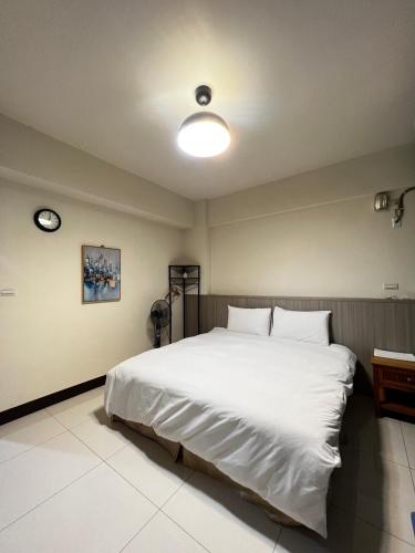 a bedroom with a large white bed in it at 好客行館 in Donggang