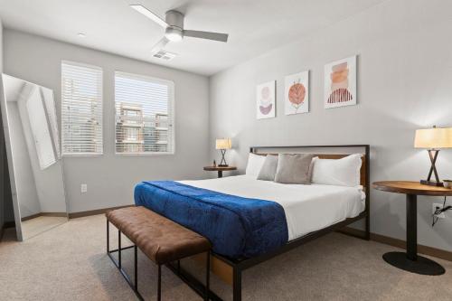 a bedroom with a bed and two tables and two windows at Cozysuites PHX RORO Gym, Pool, Pets, Parking! #9 in Phoenix