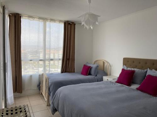 1 dormitorio con 2 camas y ventana grande en Playa Blanca, en La Serena