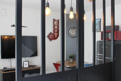 a reflection of a living room with a clock in a mirror at Escale à Clisson - L'atelier in Clisson