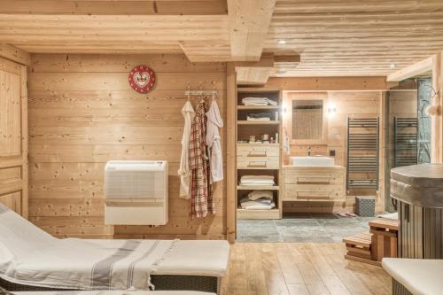 Habitación con lavabo y baño con paredes de madera. en Chalet luxe MARTA en Saint-Laurent-de-Mure