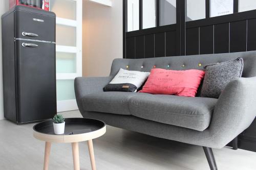 a living room with a gray couch and a table at L'atelier Clissonnais, plein centre historique in Clisson