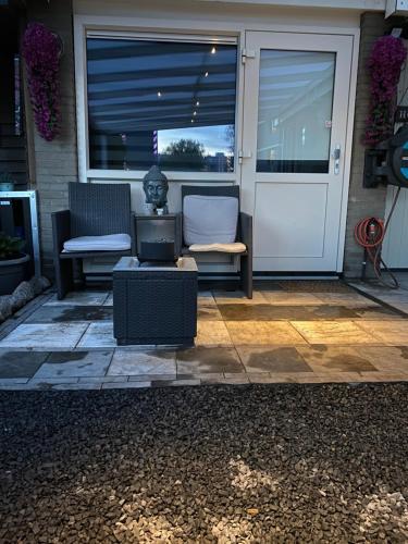 a patio with two chairs and a table and a door at Casa di maksch de miniatura in Amsterdam